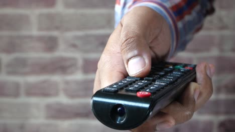 persona que utiliza un control remoto de la televisión