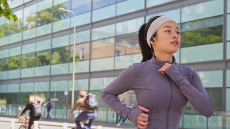 Close-Up-Of-Young-Woman-Exercising-Running-Along-City-Street-Wearing-Wireless-Earbuds