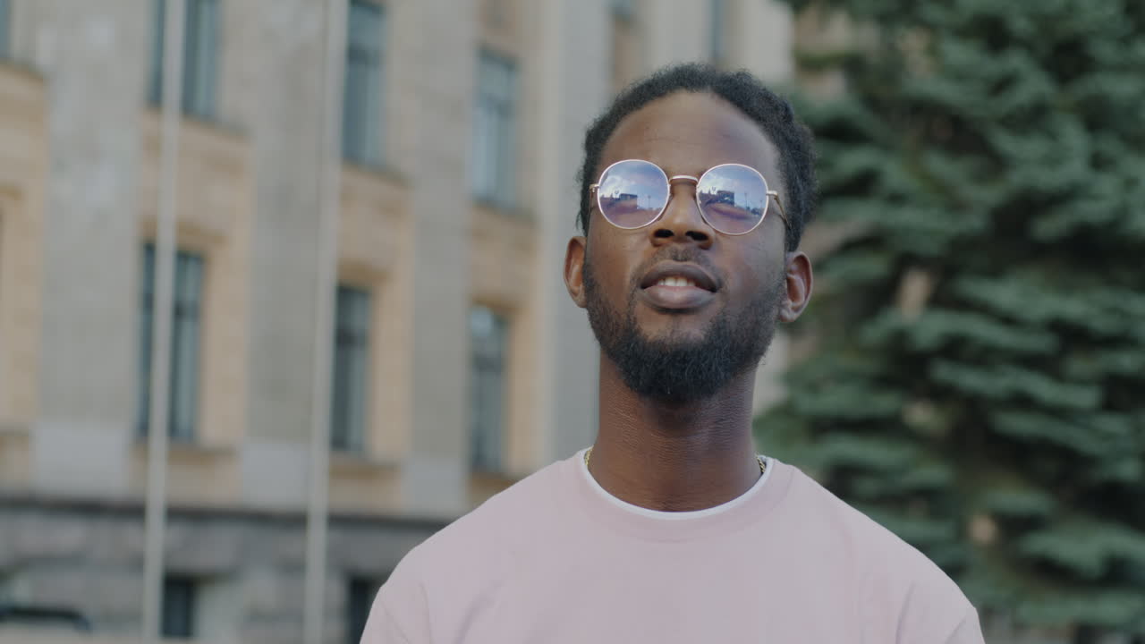 Man in Sunglasses Looking Up in City