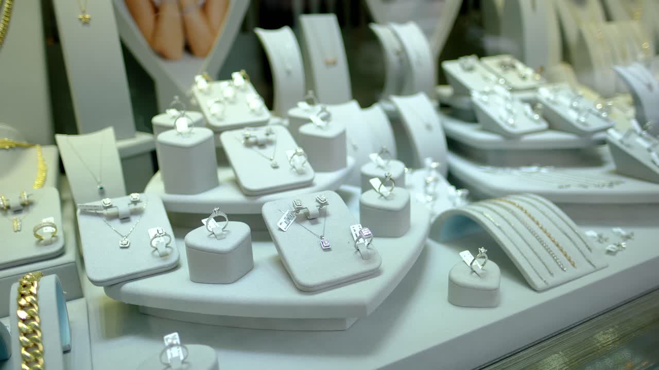 hay pendientes de oro y joyas en la ventana de la joyería jwe