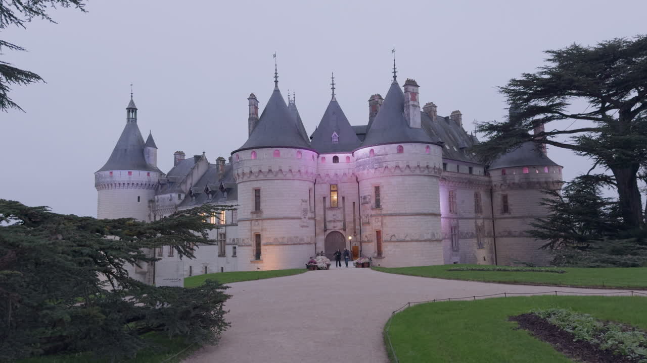 Wide pan of exterior of Château de Chaumont in cloudy France with tourists outside
