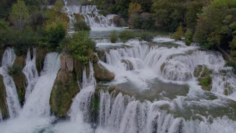 Close-up-shot-of-Krka-Waterfalls-with-green-foliage-and-turquoise-water,-aerial