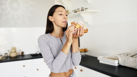mujer con un croissant en una cocina