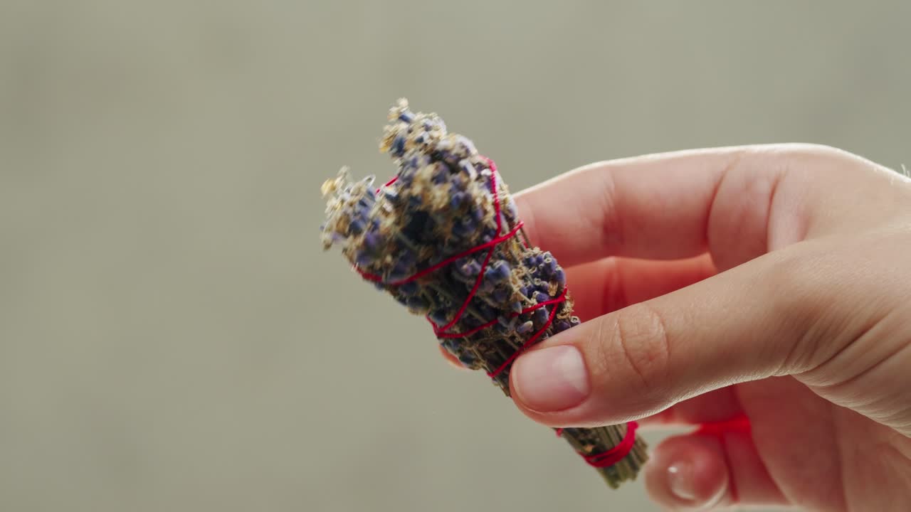 Person holding Palo Santo wood stick in hand, aromatic Palo Santo burning on black background, smoke spreading around, slow motion video clip, high quality 4k close up footage. High quality 4k footage