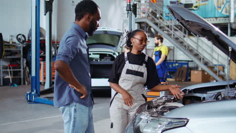 serviceman in garage fixes customers car