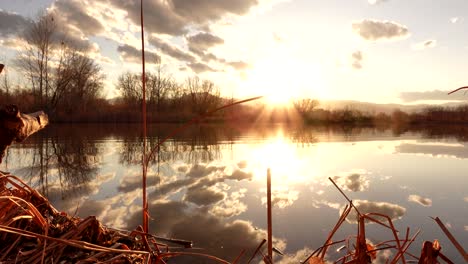 reflection of sunset and clouds over lake surface