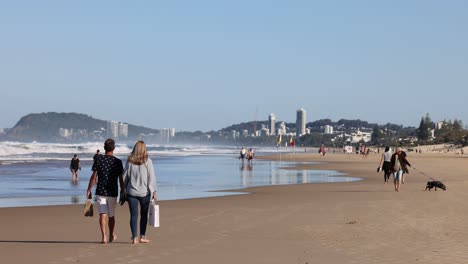 couple walking on beach with other visitors