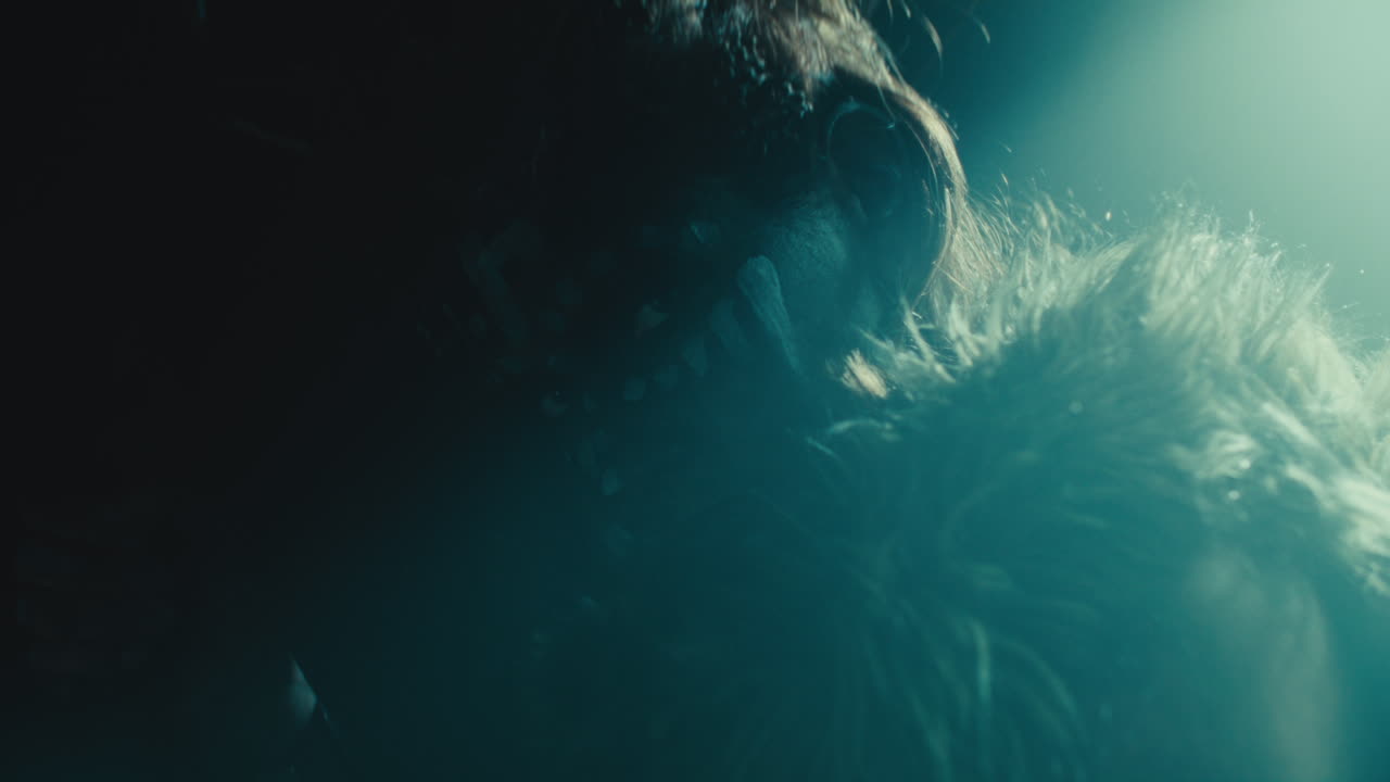 A creepy witch stands in the moody pose during the night storm