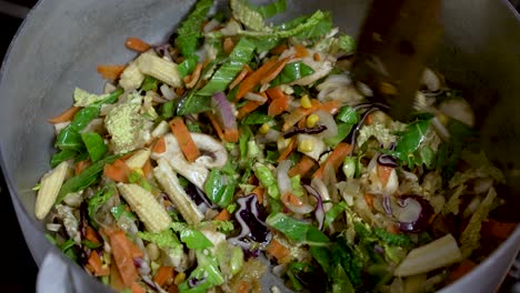 A-cooking-chef-mixes-vegetable-stir-fry-with-a-wooden-spoon,-embodying-the-essence-of-culinary-preparation-and-food-crafting