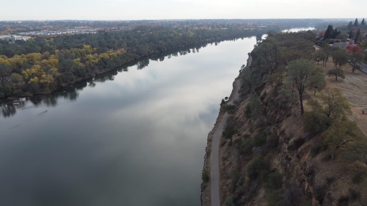 High traveling drone footage along the water with the sky reflecting off the waters surface
