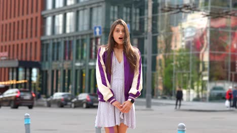joven con chaqueta púrpura y vestido en la calle de la ciudad