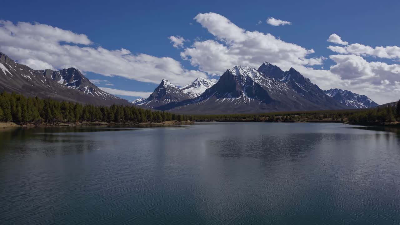 Un video sereno di un paesaggio che mostra una visuale grandangolare di un lago tranquillo con montagne maestose