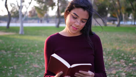 una estudiante universitaria leyendo y estudiando un libro de texto antes de la clase de literatura en el campus a cámara lenta