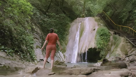 woman at a waterfall in a forest