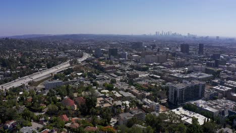 Aerial-high-panning-shot-above-Hollywood-with-Downtown-Los-Angeles-and-Highway-101-in-the-background