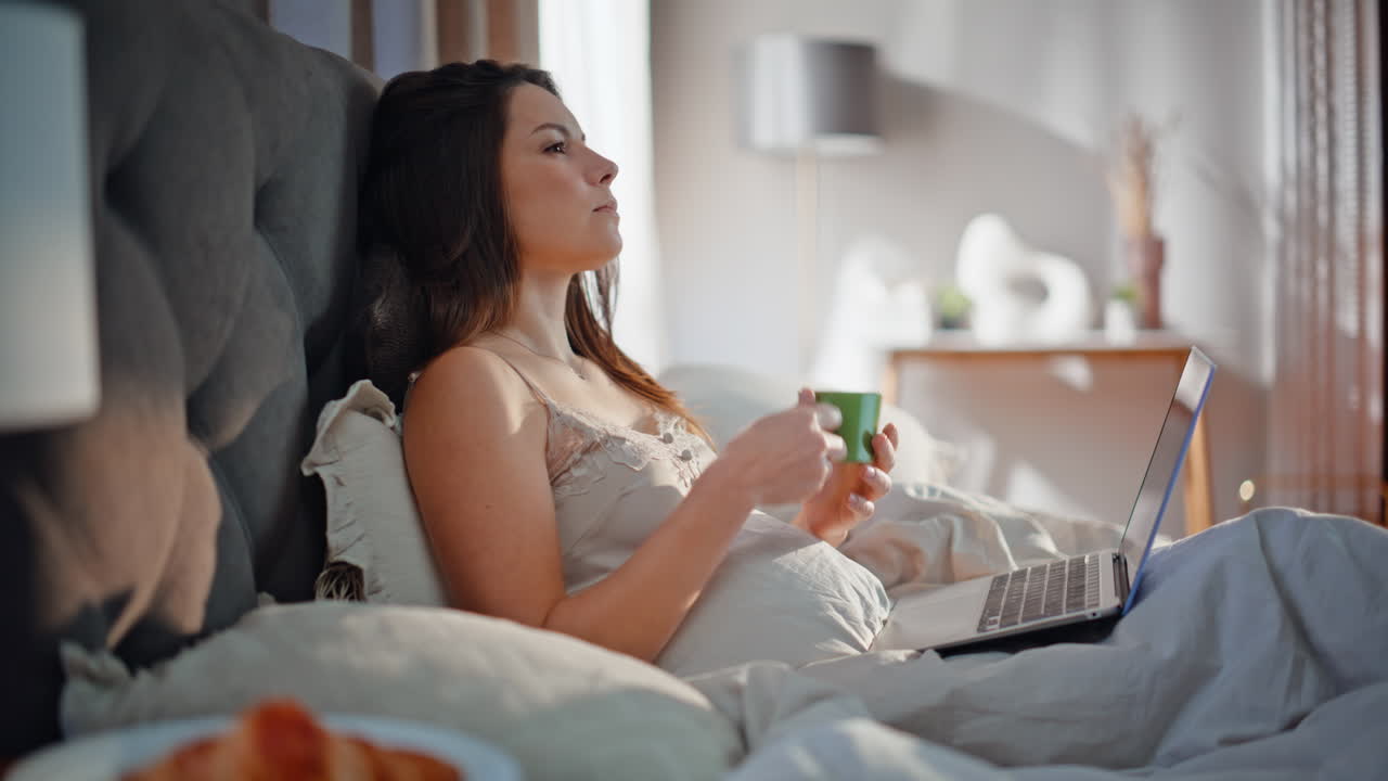 Woman freelancer working bed drinking morning coffee closeup. lady