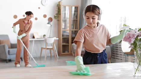 girl dusting off desktop and woman mopping floor