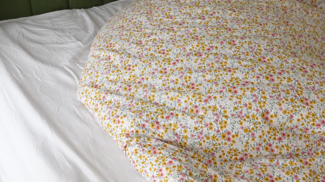Close-up of a Bed with Floral Duvet and White Sheets