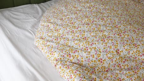 close-up of a bed with floral duvet and white sheets