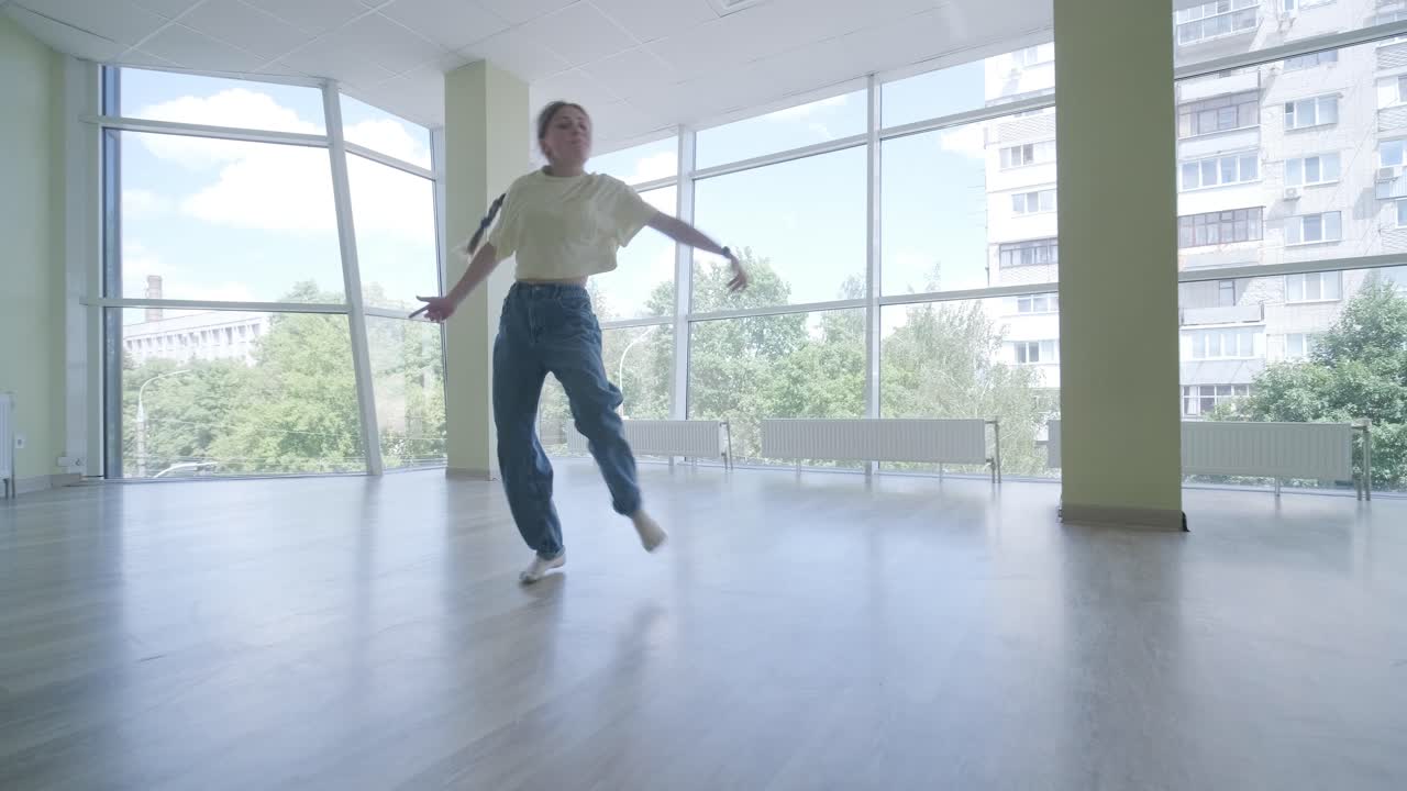 una chica joven bailando breakdance en un estudio moderno.
