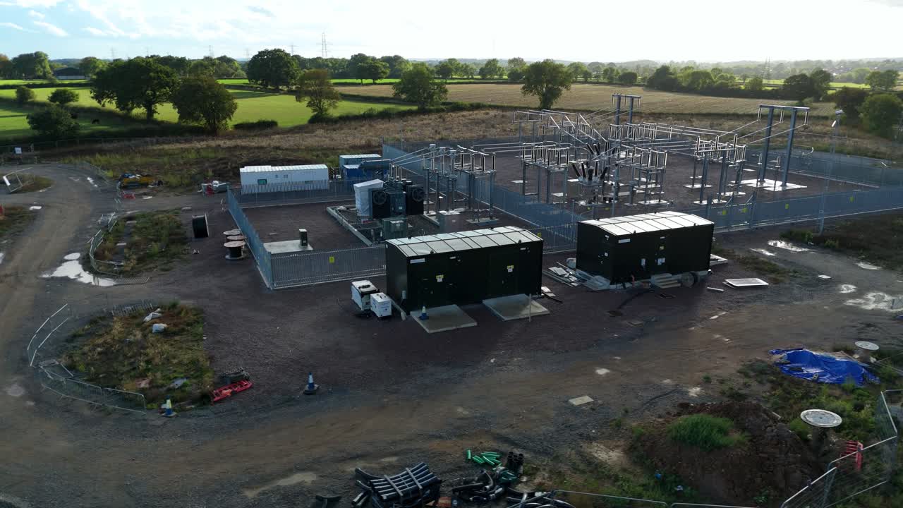 Close orbit aerial drone view of Coalville electrical substation with transformers, pylons, cables, and powerlines in central England