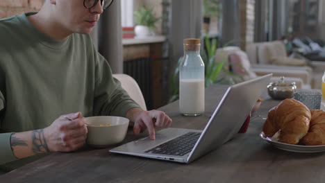 man using laptop during breakfast
