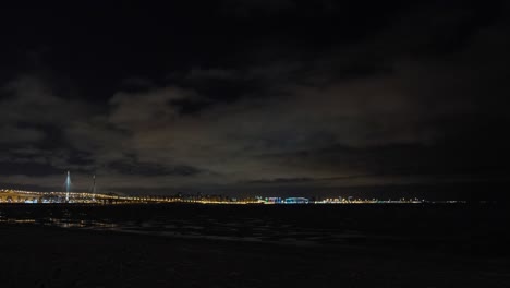 vista nocturna de una ciudad junto a la costa