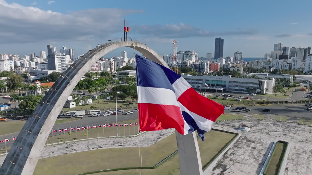Dominican Republic flag waving over triumphal arch in Plaza de la Bandera, Santo Domingo