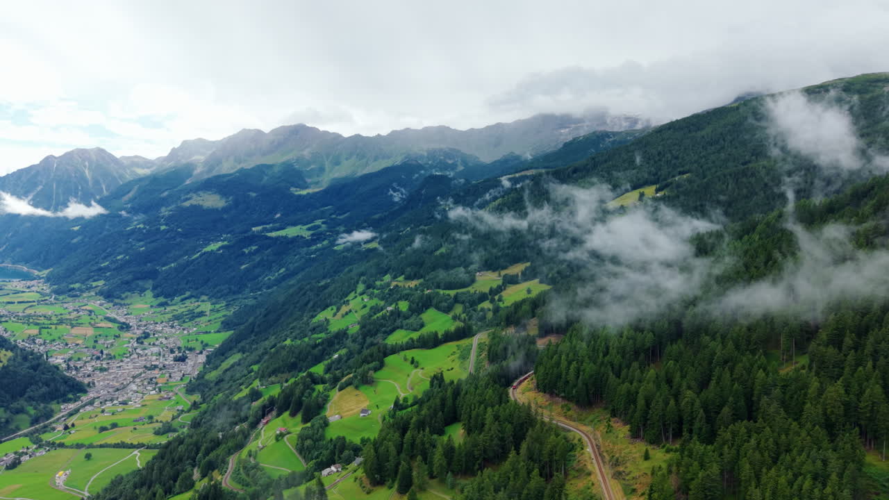Lush Green Alpine Scenery: Valley Floor, Forest, and Misty Peaks