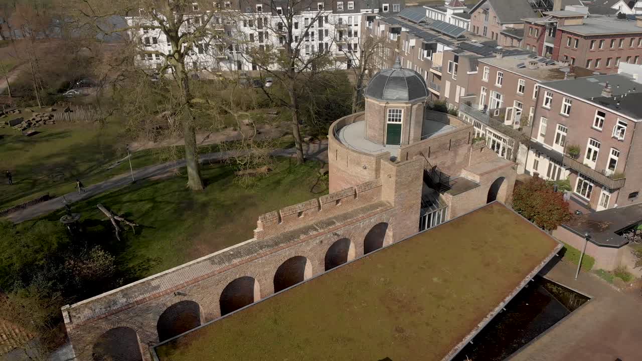 día soleado panorámica aérea lenta que muestra la parte superior de la histórica torre de la fortaleza de bourgonje y la muralla de la ciudad con el paisaje del parque en zutphen, los países bajos