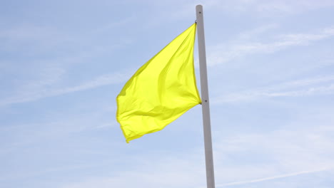 bandera amarilla de advertencia de playa, en un día de viento