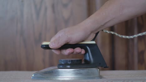 el hombre alisa la tela con hierro soviético vintage eléctrico