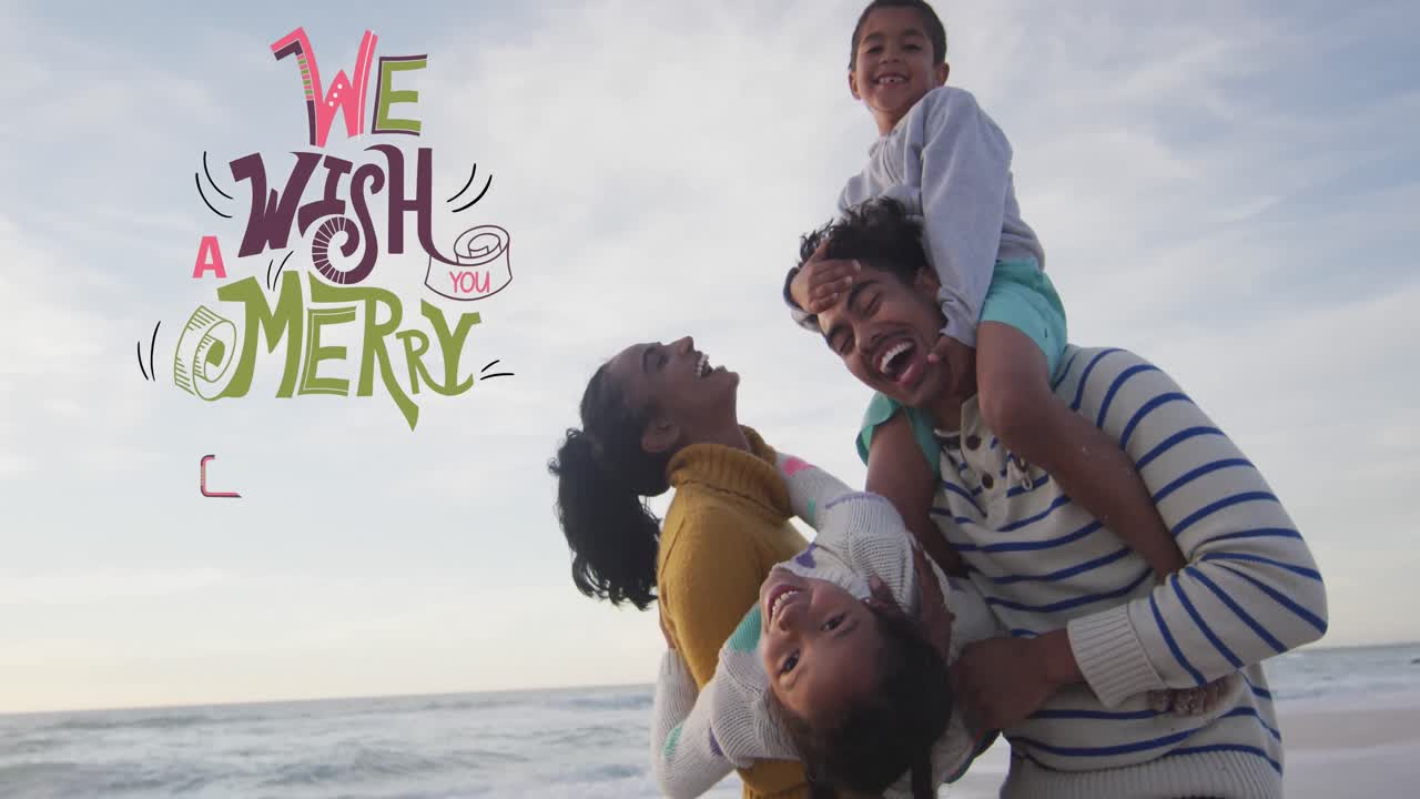Animation of merry christmas text over happy biracial parents and children laughing on beach