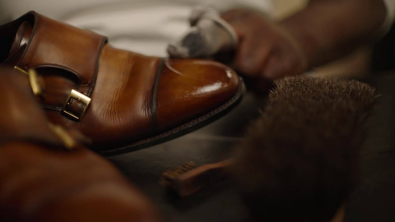 An expert shoemaker buffing and polishing a shoe to a like-new shine