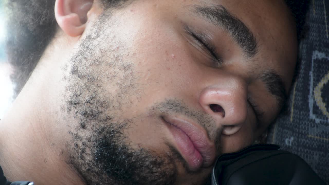 Young African American Black Man Sleeps on Bus Chair Extreme Close Up