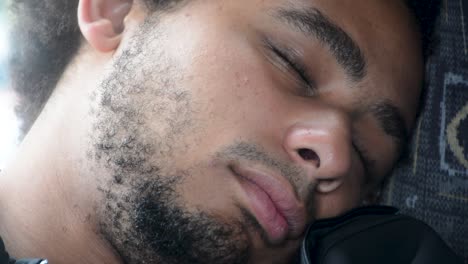 young african american black man sleeps on bus chair extreme close up