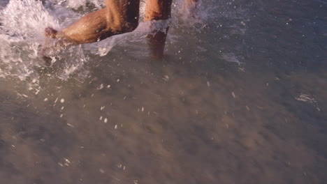 diverse group of friends swimming in the sea at sunset