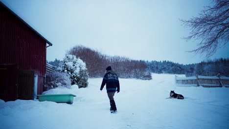un hombre arrastró la bañera vieja a través de la nieve, con su perro siguiendo de cerca - toma estática