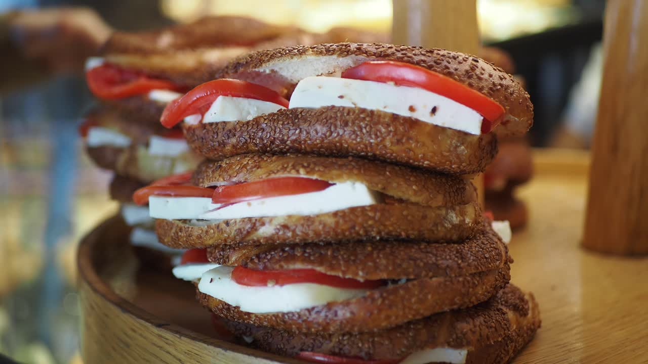 Stack of simit sandwiches with cheese and tomato