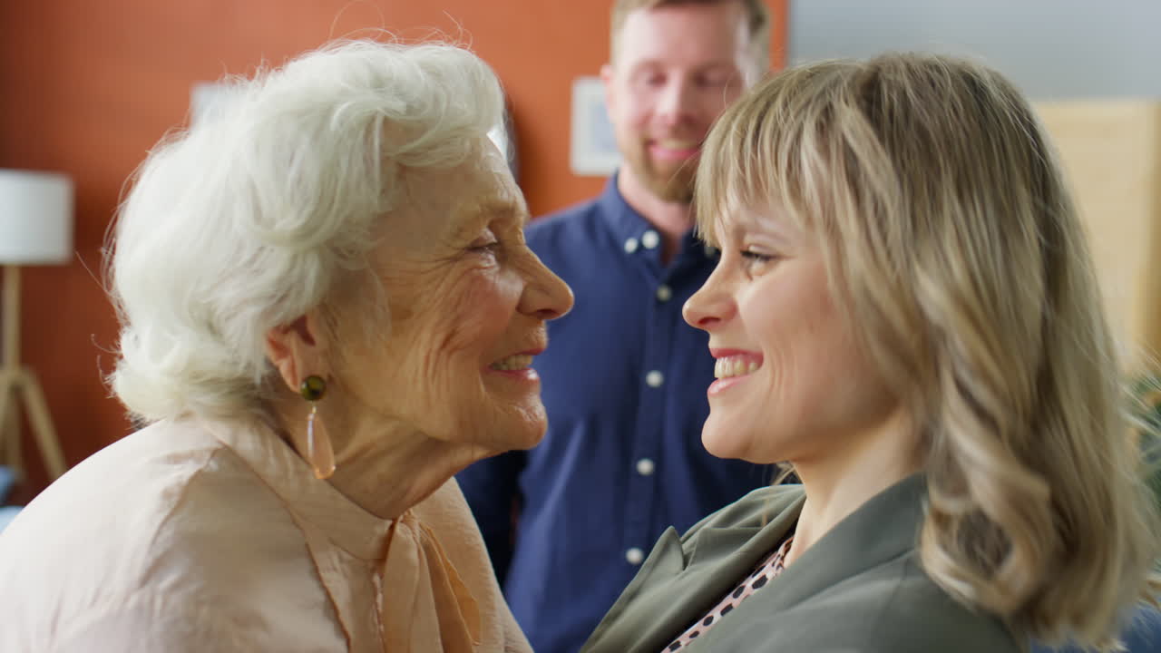 Cheerful Grandma Greeting Adult Granddaughter with Hugs