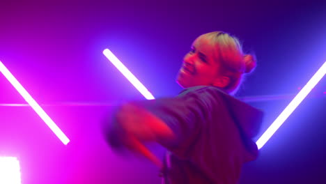 hip hop dancer performing energetic dance in club ultraviolet lights close up.