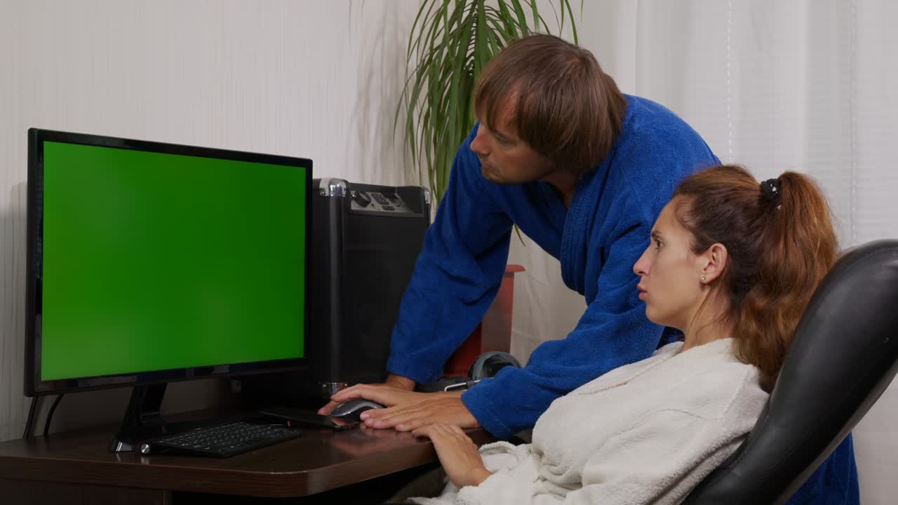 hombre de negocios y mujer de negocios en ropa de casa en casa con pantalla verde chroma clave pc en la mesa.