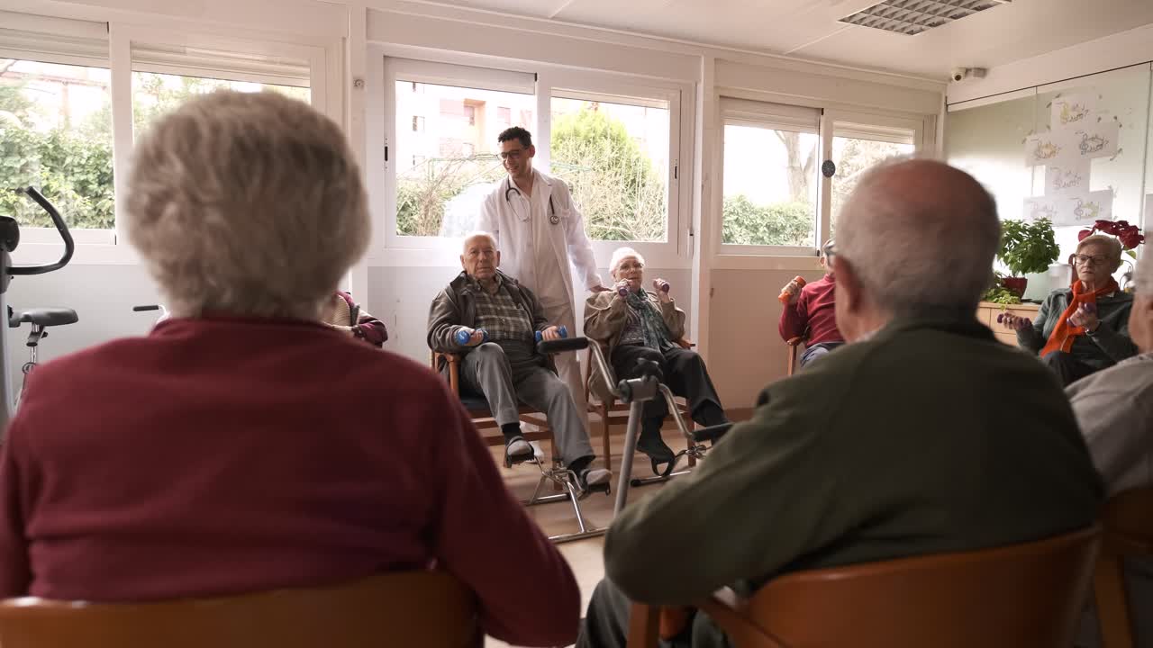 Friendly caregivers assisting senior people in pedal exercise and weightlifting at nursing home