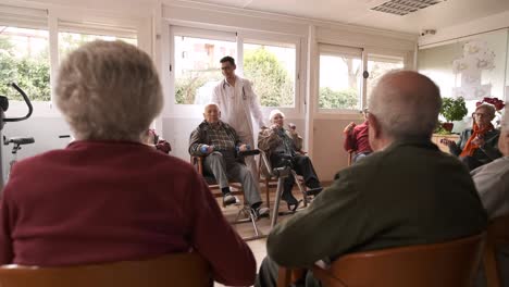 friendly caregivers assisting senior people in pedal exercise and weightlifting at nursing home