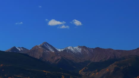 opening shot aspen mount snowmass capitol peak fall autumn sunny blue sky morning aerial drone colorado white river national forest valley snow dusting rocky mountain peaks forward pan up pan down