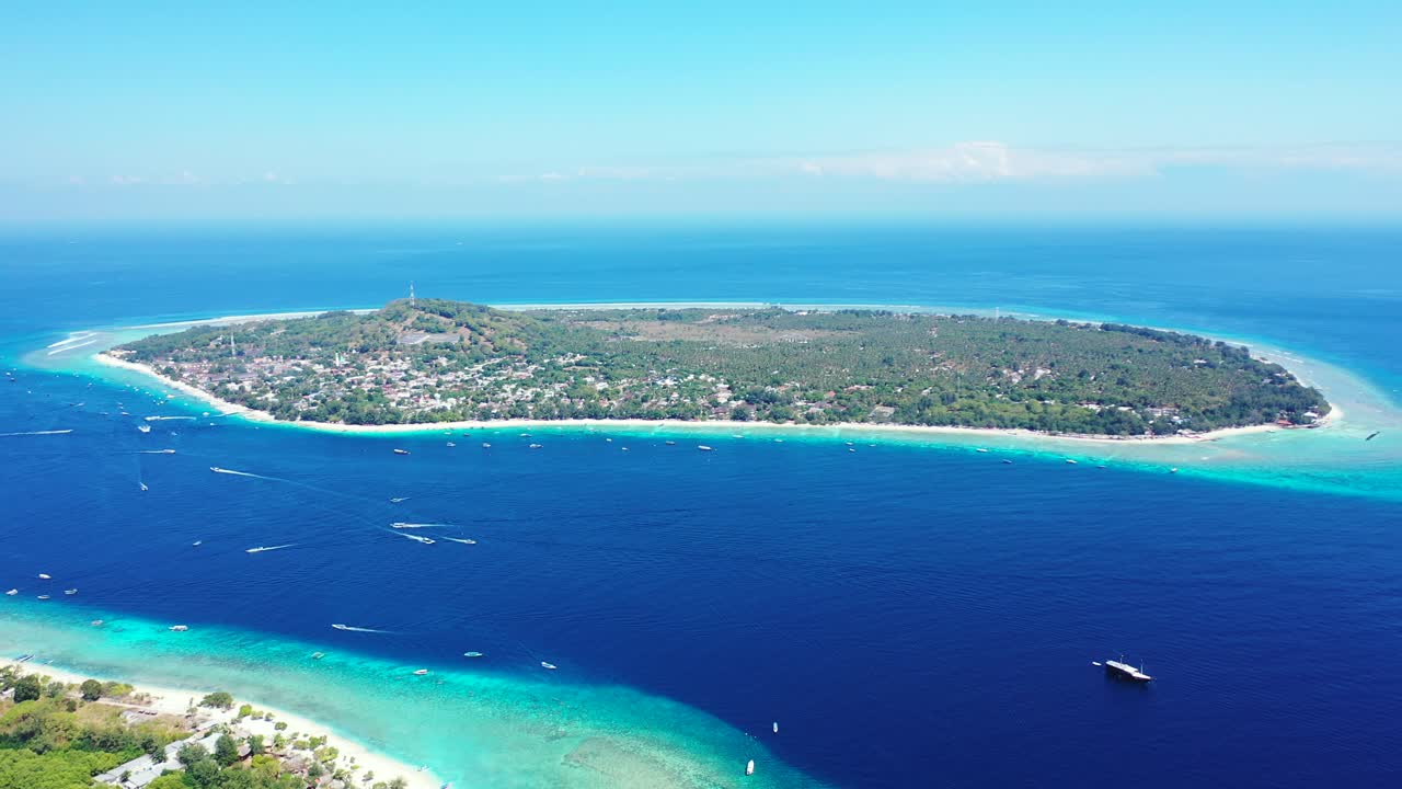 Beautiful tropical island circle shaped with lush vegetation, surrounded by turquoise ring of calm lagoon and deep blue sea, gili trawangan