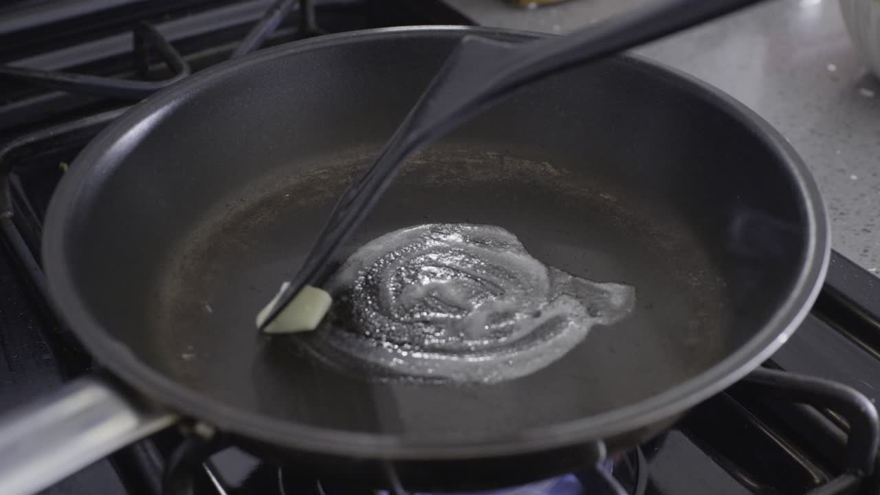 Butter in frying pan. Butter melting and being spread around the pan