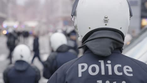 Policía-Antidisturbios-Irreconocible-Que-Protege-La-Ciudad---Vista-Desde-Atrás-Del-Policía,-Fondo-Borroso