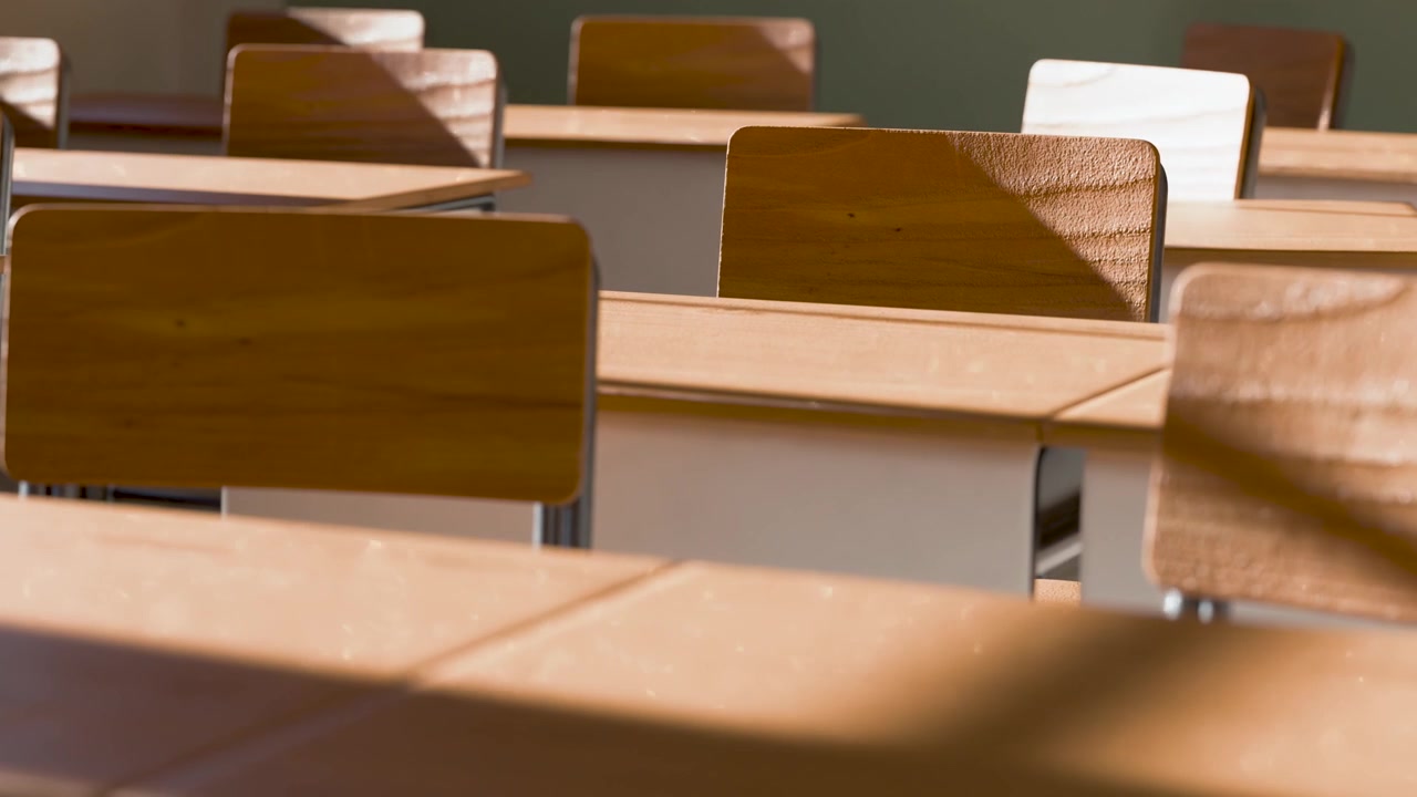Aula vuota con scrivanie e sedie di legno alla luce solare