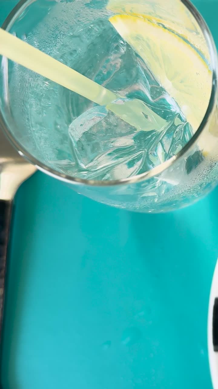 un vaso de refresco con limón y hielo en una mesa vibrante, destacando los momentos refrescantes de la cena